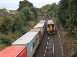 Derby_Road_-_Greater_Anglia_153335_passing_Freightliner_66538_and_container_train-800x600