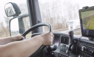 Male arms driving a truck on the road